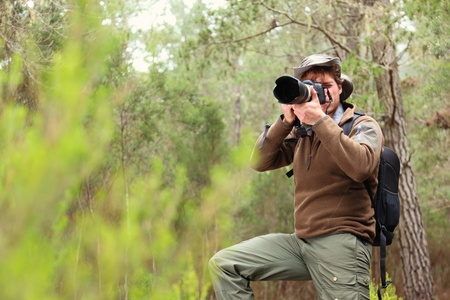 Nature photographer in forest taking pictures. Man with DSLR camera and hiking outfit. From Aguamansa, Tenerife, Spainの写真素材