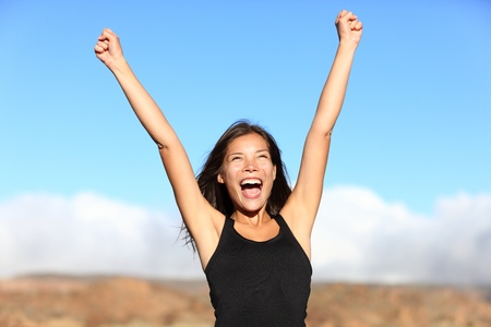 Hiker cheering. Woman hiking cheerful with arms stretched screaming of joy on top of mountain. Beautiful sporty mixed ethnicity woman outdoor.の写真素材