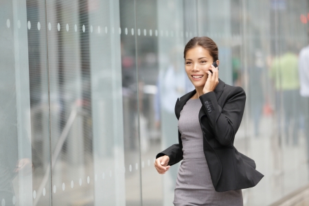 Businesswoman on cellphone running while talking on smart phoneの写真素材