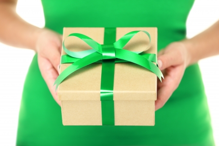 Gift / present. Woman hands showing and giving gifts. Closeup of present made of recycled carton and green ribbon on white background.の写真素材