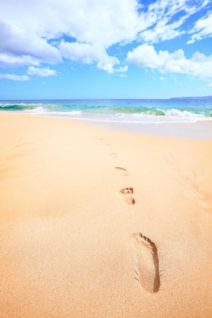 Beach travel vacation concept - footsteps in sand on beautiful sunny summer day during getaway holidays under the blue sky. From Makena beach, Maui, Hawaiiの写真素材