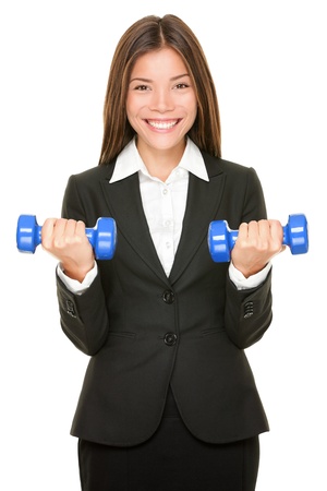 Business woman in suit lifting dumbbell weightsの写真素材