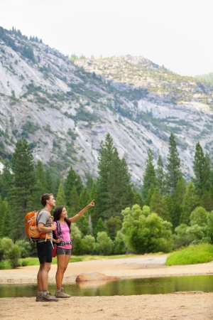 Hiking people on hike in mountains in Yosemite  Hikers young couple pointing looking up in mountain landscape in Yosemite National Park, California, USA  Multicultural couple active outdoors の写真素材