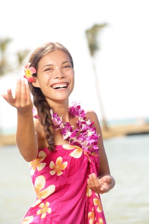 Hula dancer woman dancing hula dance on Hawaii wearing Hawaiian orchid flower lei smiling happy on beachの写真素材