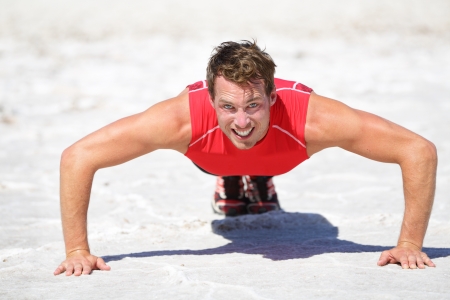 Push-ups - Fitness man crossfit training outdoors in desert showing power, strength and determination. Male athlete doing push up in extreme nature landscape.の写真素材