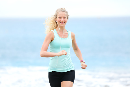 Running woman jogging outside on beach. Female fitness runner girl jogger training outdoors...