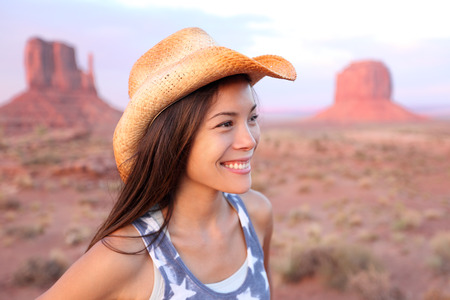 Cowgirl woman happy portrait in Monument Valley wearing cowboy hatの写真素材