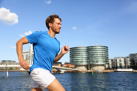 Runner running in urban Copenhagen city. Man exercising jogging in downtown, Bryggen, Copenhagen,...