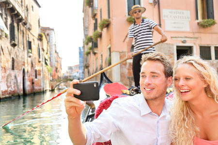 Travel couple in Venice on Gondole ride romance in boat happy on vacation holidays. の写真素材