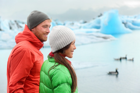 Hiking people visiting Jokulsarlon glacial lagoon / glacier lake on Iceland. Happy tourists on travel enjoying beautiful Icelandic nature landscape in edge of Vatnajokull National Park.の写真素材