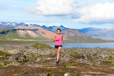 Runner woman trail running in nature. Female fitness girl athlete cross country trail running in...