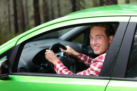 Electric car driver - green energy biofuel concept. Male behind wheel. Man driving new vehicle in...