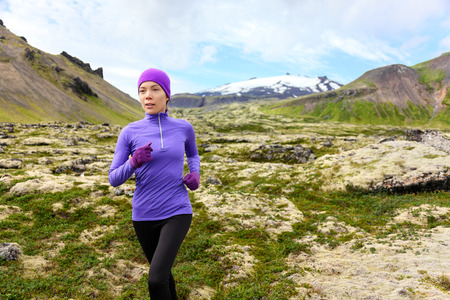 Running woman exercising - trail runner athlete. Fit female sport fitness model training jogging...