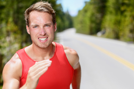 Man runner running on road training, jogging and exercising for trail run marathon endurance race. Fitness healthy lifestyle concept with male athlete trail runner.の写真素材
