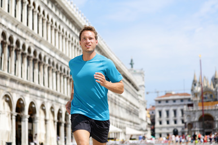 Running runner man jogging in Venice. Male sport athlete training on travel vacation as tourist on Piazza San Marco Square, Venice, Italy, Europe.の写真素材
