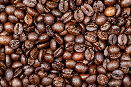 Coffee beans texture background. Closeup of fresh roasted bag of dark roast coffee beans pattern, useful for text copy space, element detail or advertisement background.の写真素材