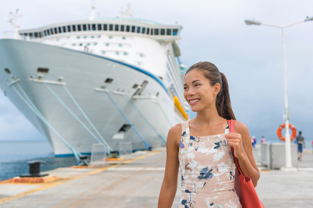 Cruise ship passenger leaving boat for shore excursion in harbour. Asian woman tourist spending a day in port of call of Caribbean travel destination.の写真素材
