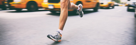 Runner athlete running in city street banner. Sport man training outside in urban background next to yellow cabs cars taxi in new york NYC.の写真素材
