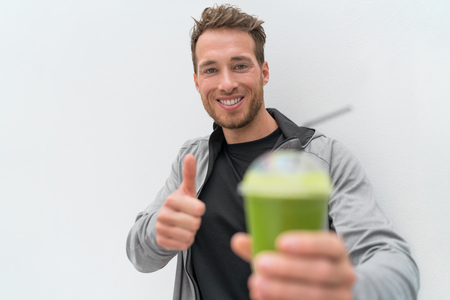 Happy healthy eating smoothie juice man thumbs up. Health food person drinking weight loss sport green smoothie drink. Fit nutrition lifestyle.の写真素材
