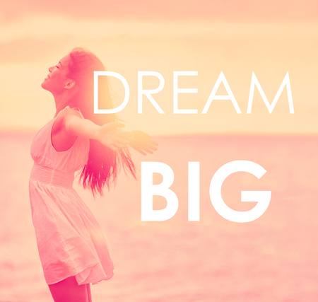 DREAM BIG inspirational message written on motivational picture of carefree girl happy with arms open in freedom at beach sunset. Life happiness motivation quote for dreaming big in your life.の写真素材