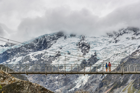 Hooker Valley Track hiking trail, New Zealand. Second swing bridge crossing the river on the Hooker Valley track, Aoraki, Mt Cook National Park with snow capped mountains landscape.の写真素材