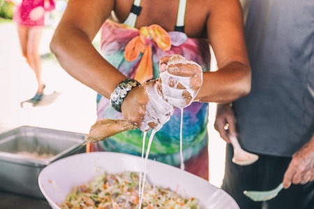 Coconut milk fresh pressed handmade. Woman making homemade recipe pressing natural coconut with hands to demonstrate Polynesian culture, local typical food. French Polynesia, Tahiti people lifestyle.の写真素材