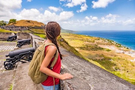Tourist girl on St Kitts island cruise travel destination visiting Brimstone Hill Fortress National Park on vacation. Caribbean cruise ship woman walking on cannon lookout on summer holidays.の写真素材