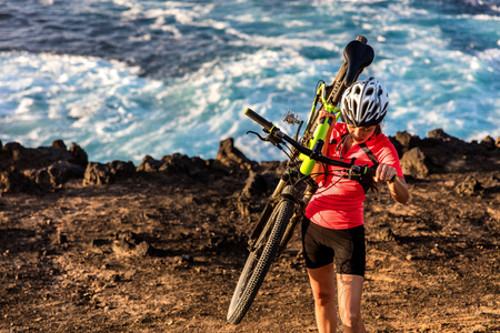Mountain biking carrying bike uphill walking up hill. MTB biker cyclist riding outdoors. Cycling sports.の写真素材