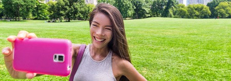 Selfie photo with phone girl tourist enjoying summer travel vacation. Happy Asian woman taking...