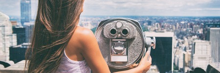 New York city tourist looking at view of NYC skyline with binoculars. Tourism in the United States of America travel banner panorama lifestyle people. American vacation.の写真素材