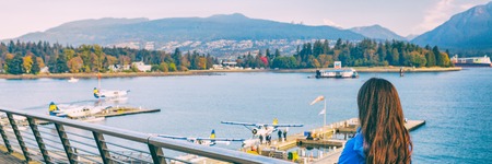 Woman walking in Coal Harbour in Vancouver city in fall, BC, Canada. Autumn travel lifestyle panorama banner.の写真素材