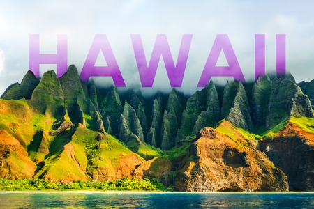 HAWAII title written over famous hiking or cruise tourist destination Na Pali Coast mountains in Kauai island, Hawaii, USA. Background for tourism travel vacation luxury holidays.の写真素材