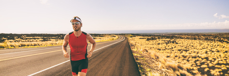Running man training for triathlon sport run race in Hawaii. Banner panorama landscape sunset nature, triathlete runner jogging.の写真素材