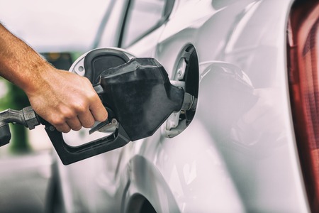 Car pumping gas at gas pump. Closeup of man pumping gasoline fuel in car at gas station.の写真素材