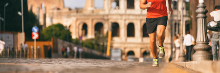 Runner running in Rome city street at marathon run. Banner panorama of athlete's legs and running...
