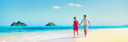 Hawaii vacation couple walking relaxing on white sand and pristine turquoise ocean water on Hawaiian beach Lanikai, Oahu island, USA. Holiday background with blue sky copy space for travel concept.の写真素材