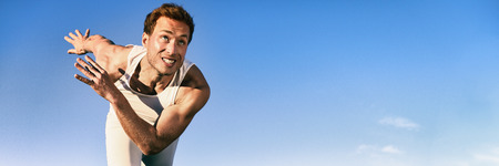 Sprinter athlete sprinting running at start of race competition outdoors. Runner man fast on track. Blue background banner.の写真素材