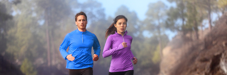Running athletes jogging on trail run - active healthy lifestye panorama banner. Couple runners...
