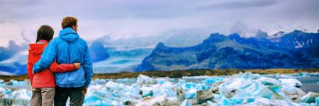 Iceland glacier landscape tourists couple at Jokulsarlon lake. Winter adventure hiking people. Panorama banner background.の写真素材