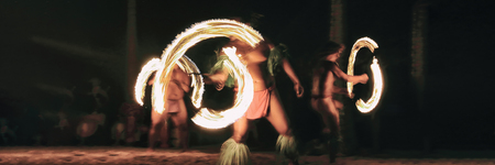 Luau party polynesian fire dancers throwing fire torches at night on beach resort. Hawaiian cultural...