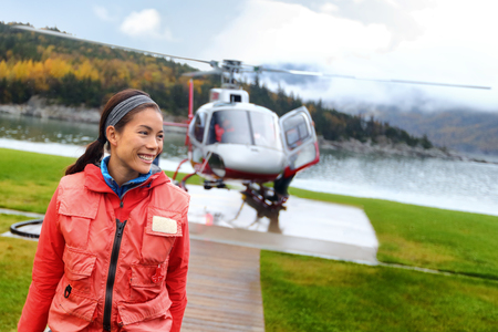 Helicopter woman tourist taking flight on tour excursion. Asian woman cruise passenger on shore activity doing helicopter ride.の写真素材