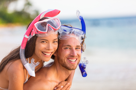 Snorkel beach summer happy couple holiday portrait. Travel vacation snorkelers smiling asian woman, caucasian man living a healthy lifestyle with diving mask at snorkeling tropical vacations.の写真素材
