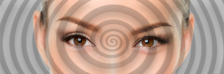Hypnosis spiral over eyes of woman hypnotized closeup banner panorama. Asian girl portrait background.の写真素材