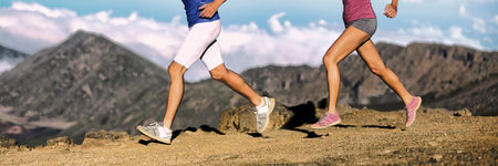 Trail running athletes legs of runners shoes and shorts, sportswear cross-country running on volcano...