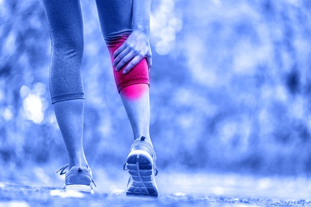 Cramps in leg calves or sprain calf on triathlete runner. Sports injury concept with running man.