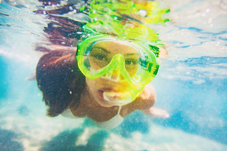 Snorkel water sport activity young Asian woman swimming underwater with snorkeling mask on Caribbean travel vacation having fun. Beach watersport active lifestyle.の写真素材