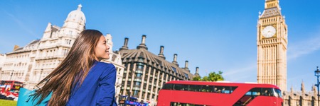 Happy tourist woman relaxing in London city at Westminster Big ben and red bus. Europe destination...