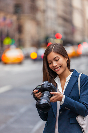 Asian woman photographer taking pictures with professional dslr camera on photography course in New York city street, NYC Usa travel.の写真素材