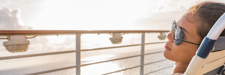Cruise ship vacation travel woman relaxing panoramic crop. Banner of girl with sunglasses lying down sun tanning on balcony. Suntan carefree. Horizontal copy space. Caribbean travel.の写真素材