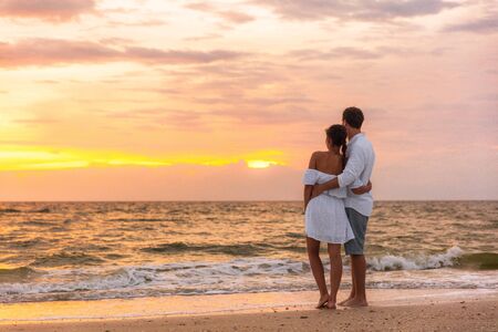 Honeymoon couple walking on sunset romantic stroll on Lover's key beach in Florida enjoying evening light relaxing on tropical summer vacation travel holiday. Two adults silhouettes lifestyle.の写真素材